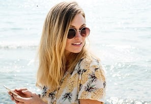 women with cellphone at beach