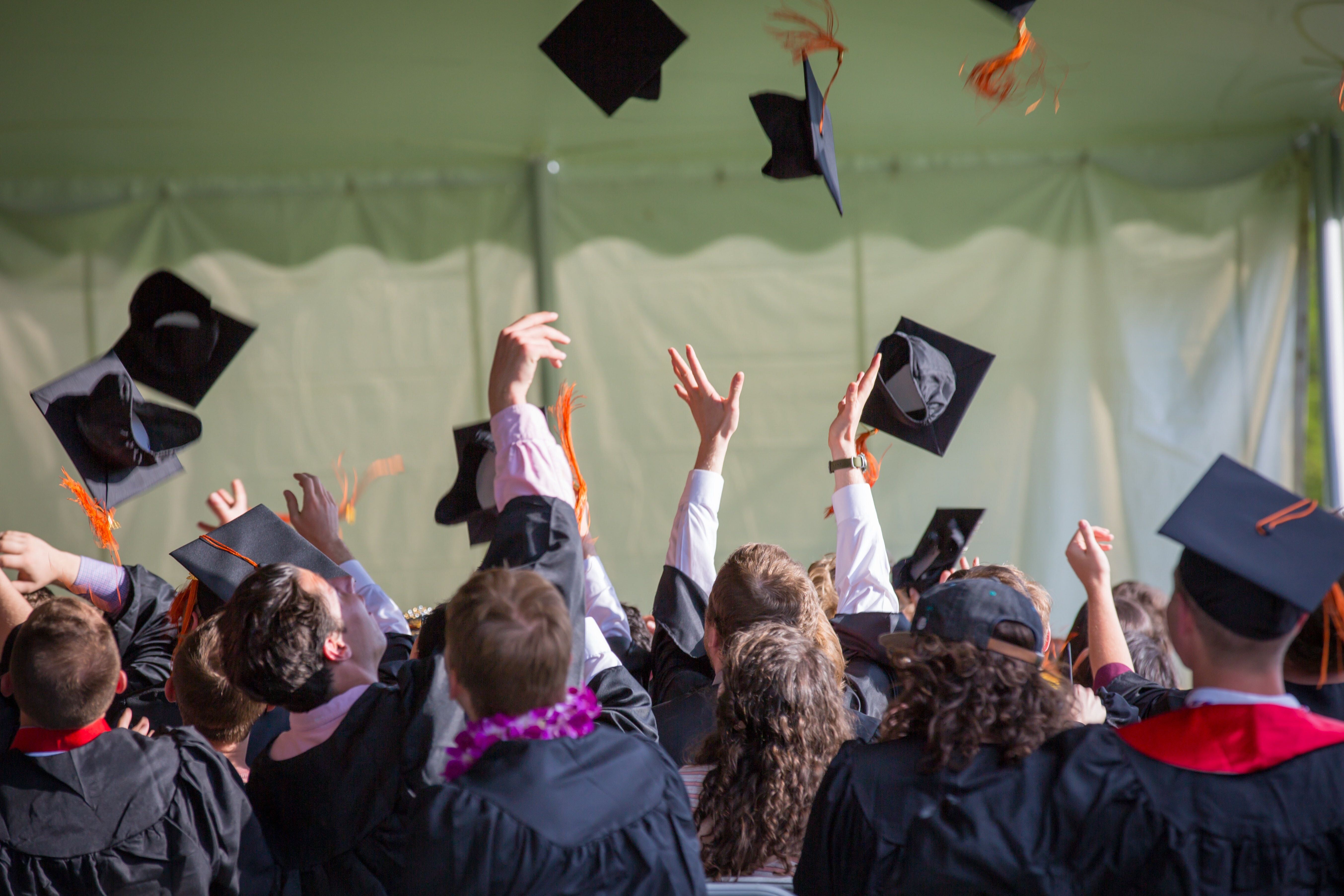 A picture of graduating students tossing their caps in the air after graduation