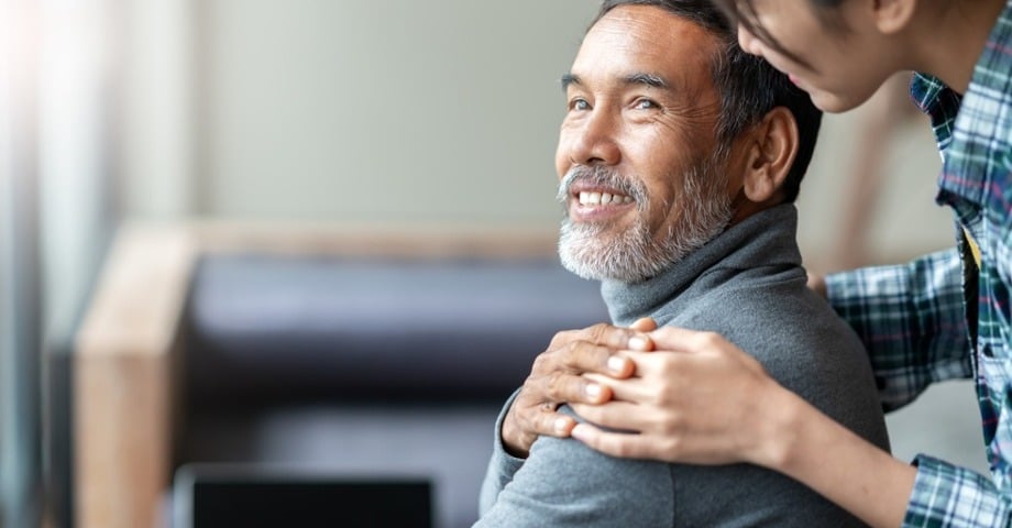 Man smiling over his shoulder and holding hands with someone off screen