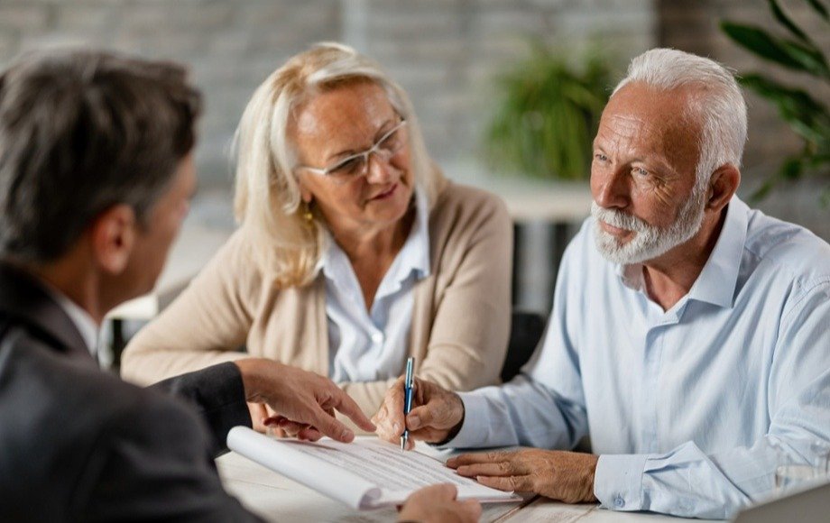 Older couple looking at paperwork with a bank employee