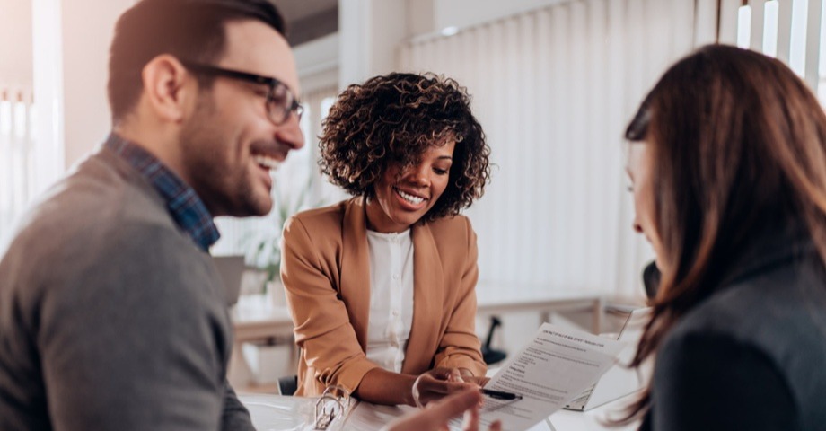 Woman and man smiling looking at paperwork 