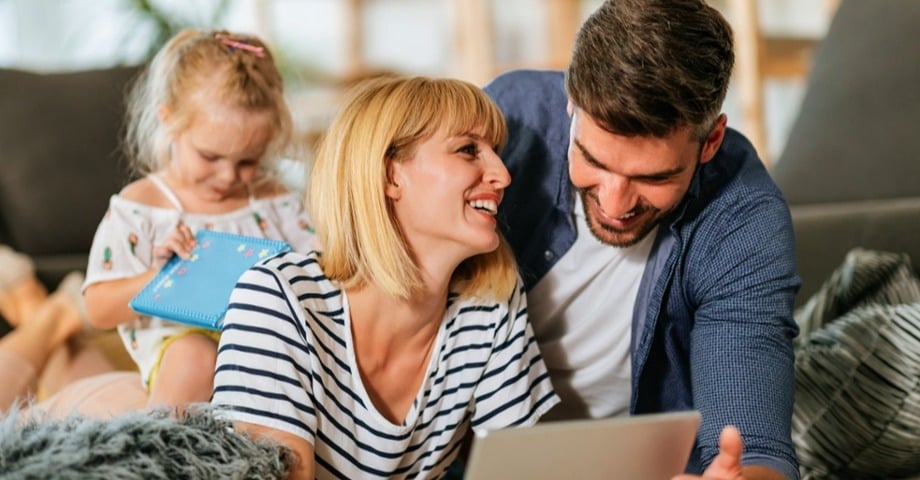 Couple and young daughter looking at a tablet