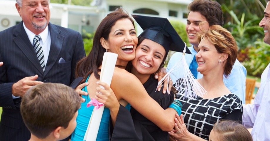 Mom hugging daughter graduate smiling