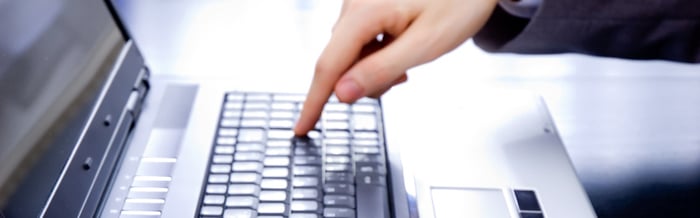 Finger pressing one key on a keyboard