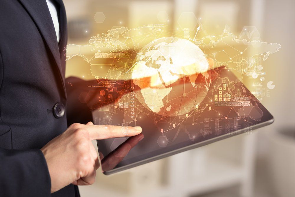 Person in a blazer using a tablet with a golden globe popping out of it