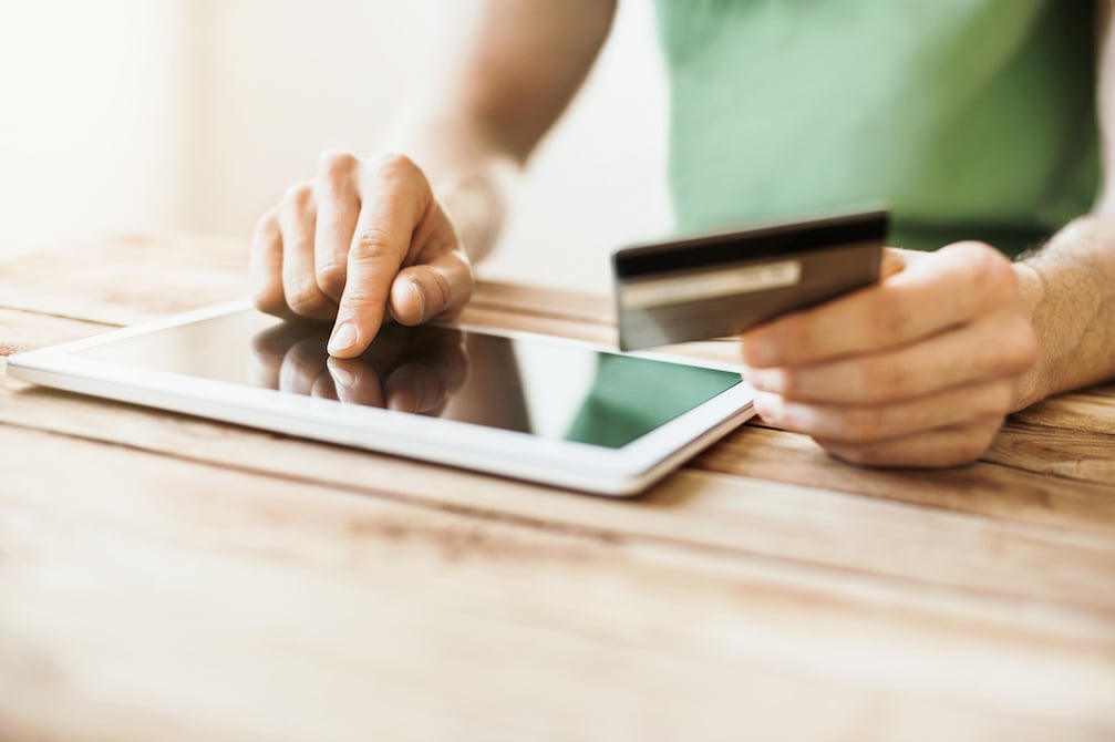 person typing in card information on a tablet, no face shown