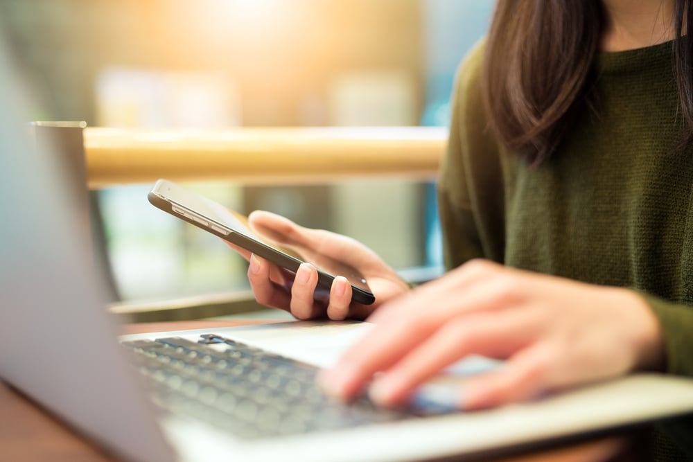 woman with laptop and phone