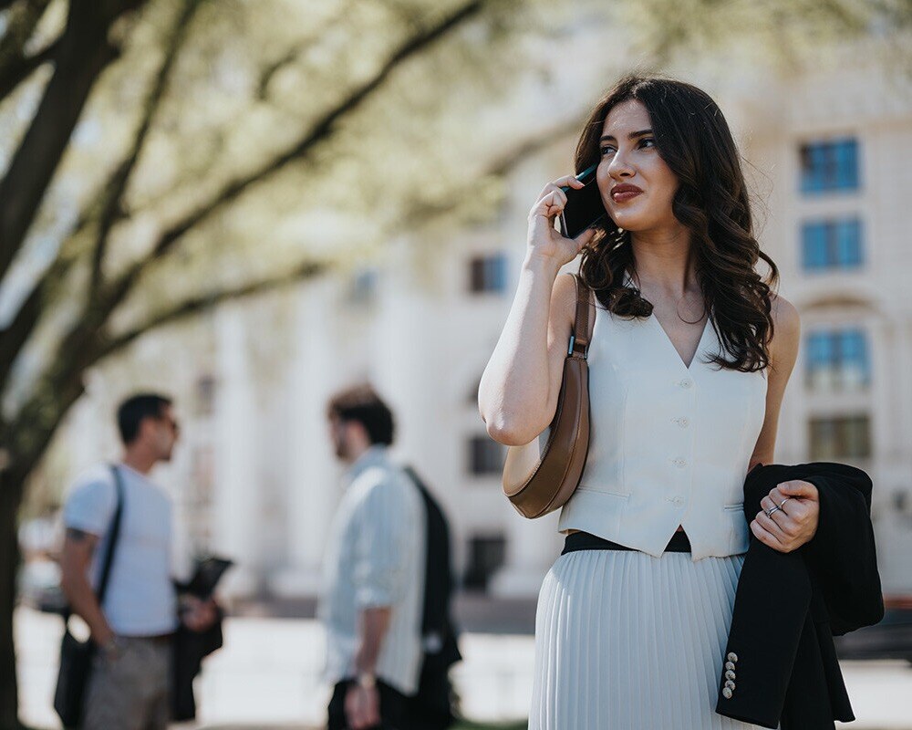 young-female-professional-walking-and-using-mobile-device