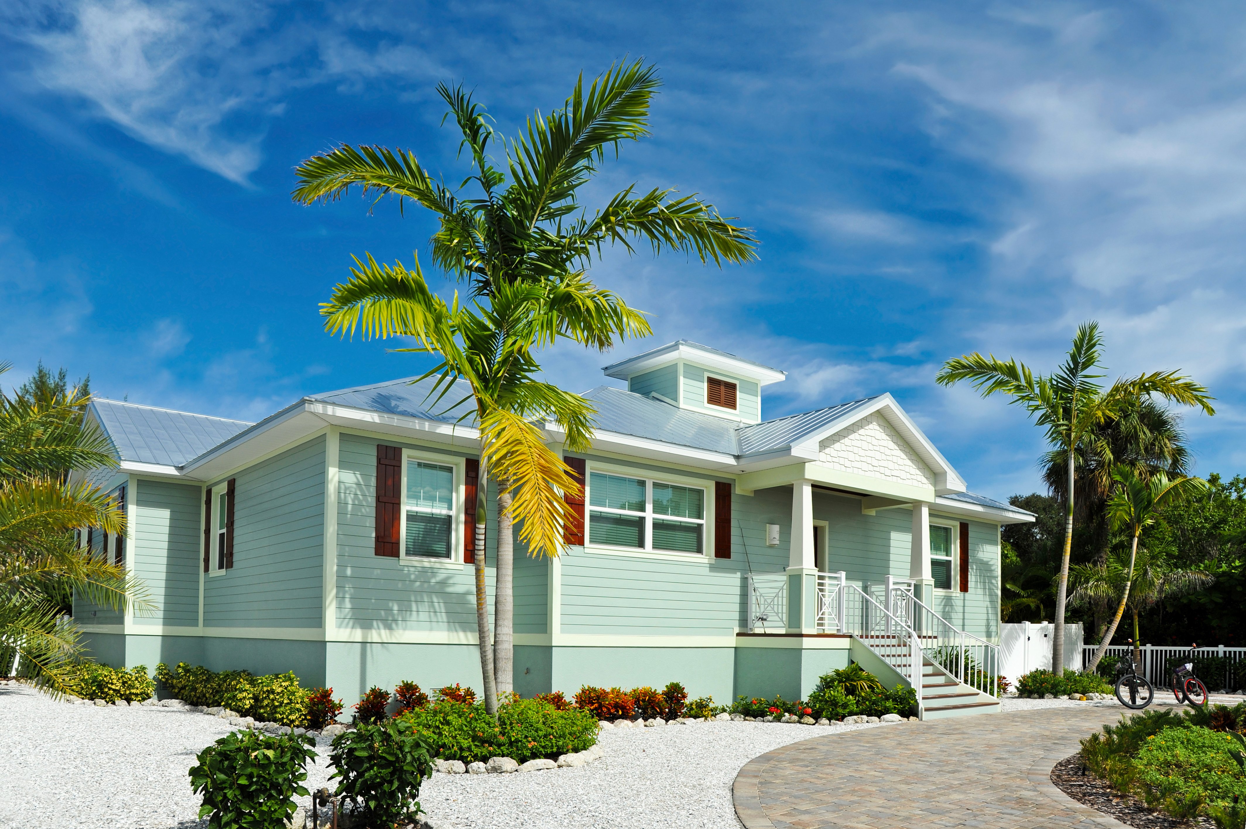 green beachy building with palm tree out front