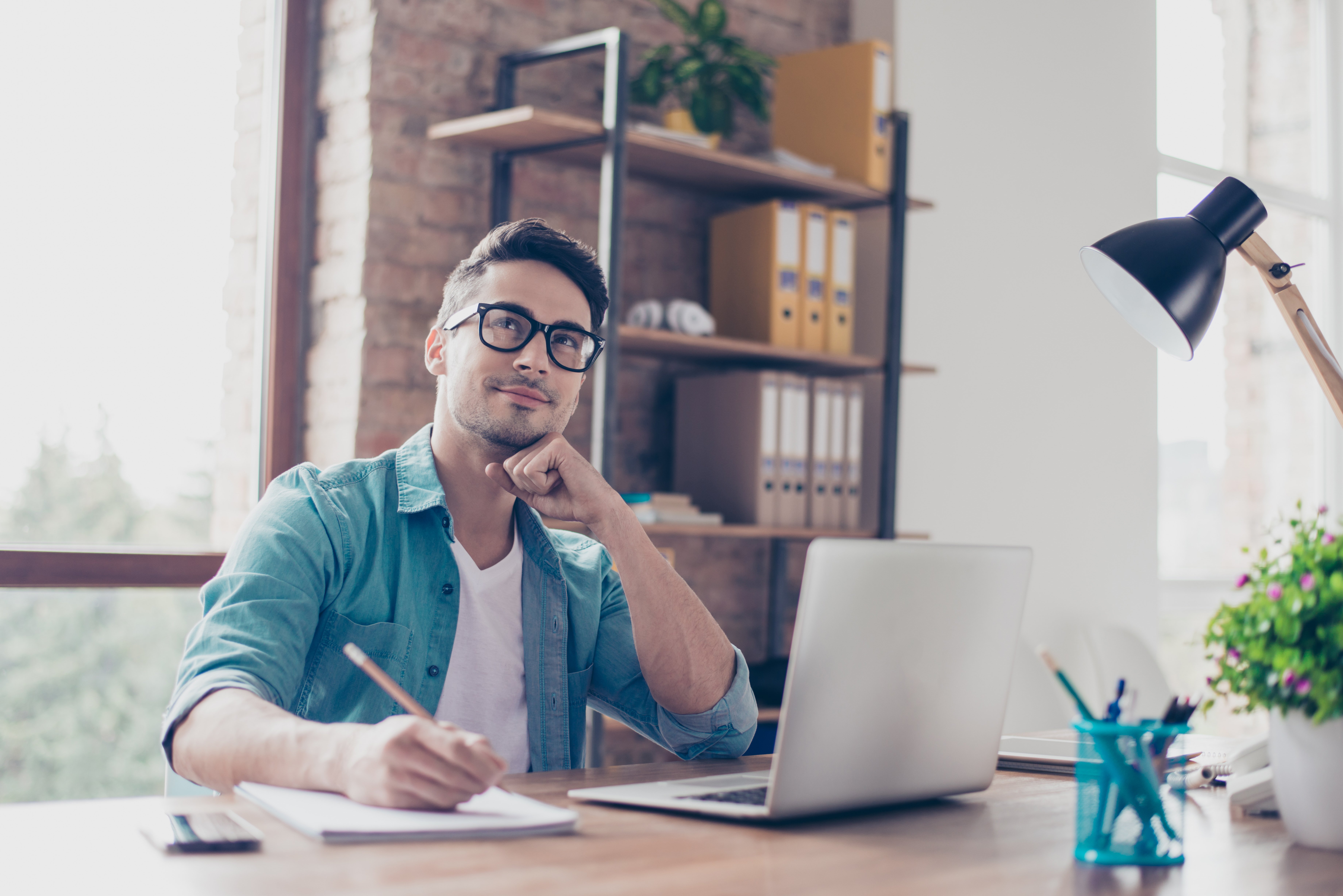 man sitting at laptop looking up